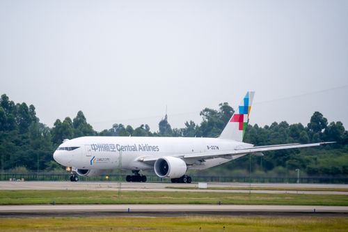 Free Central Airlines cargo aircraft on runway surrounded by greenery, ready for takeoff. Stock Photo