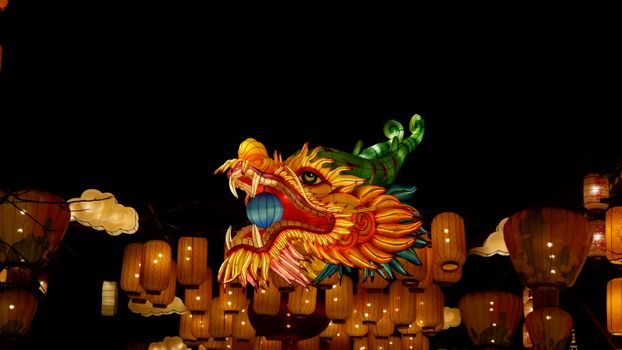 Colorful dragon lantern amidst glowing lanterns celebrating a night festival.