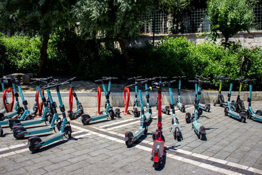 A row of electric scooters lined up in an outdoor parking lot in Istanbul, Turkey.