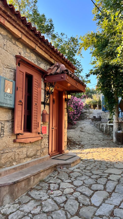 Free Charming rustic stone house with wooden shutters and Mediterranean architecture in Aegean village scenery. Stock Photo