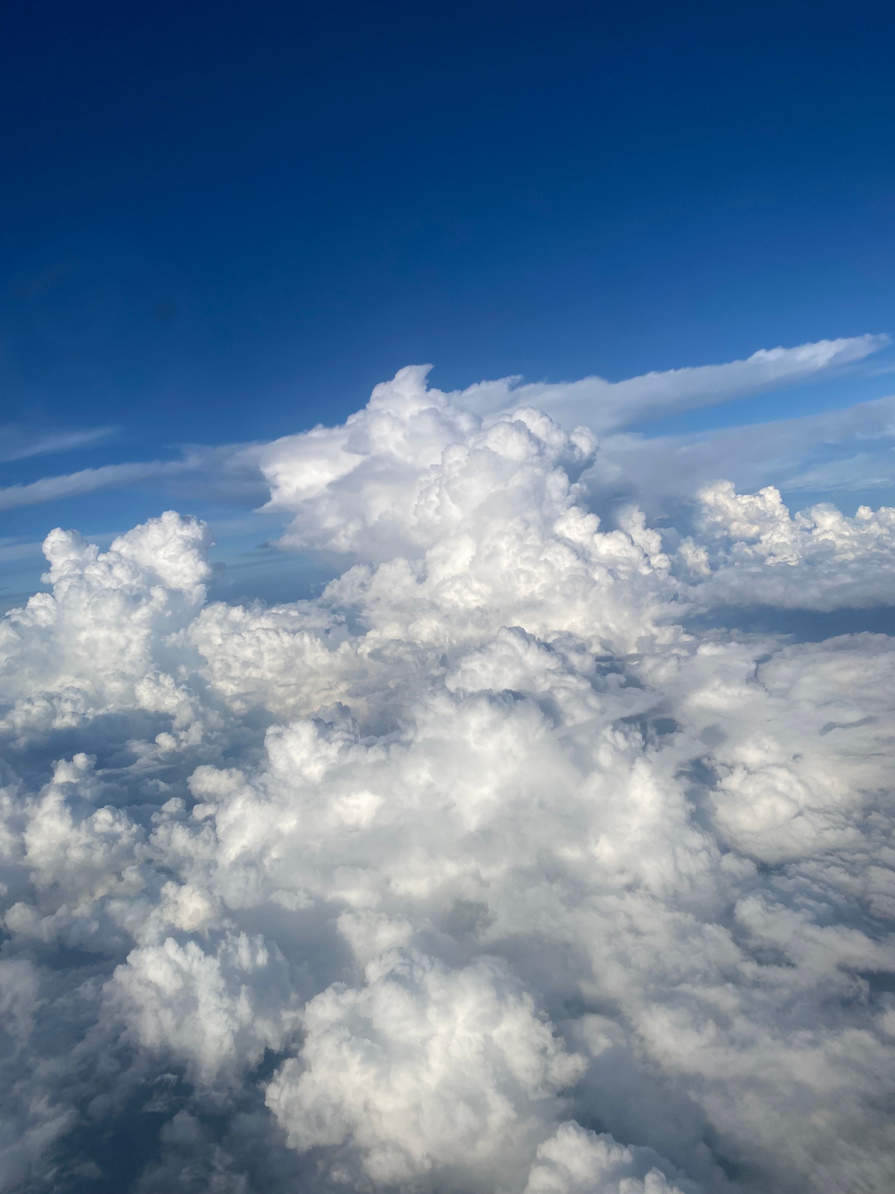 A breathtaking aerial view of cumulus clouds against a vibrant blue sky, showcasing nature's beauty.
