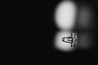 一枚令人惊叹的钻石订婚戒指陈列在黑色反光表面上，配以优雅的灯光