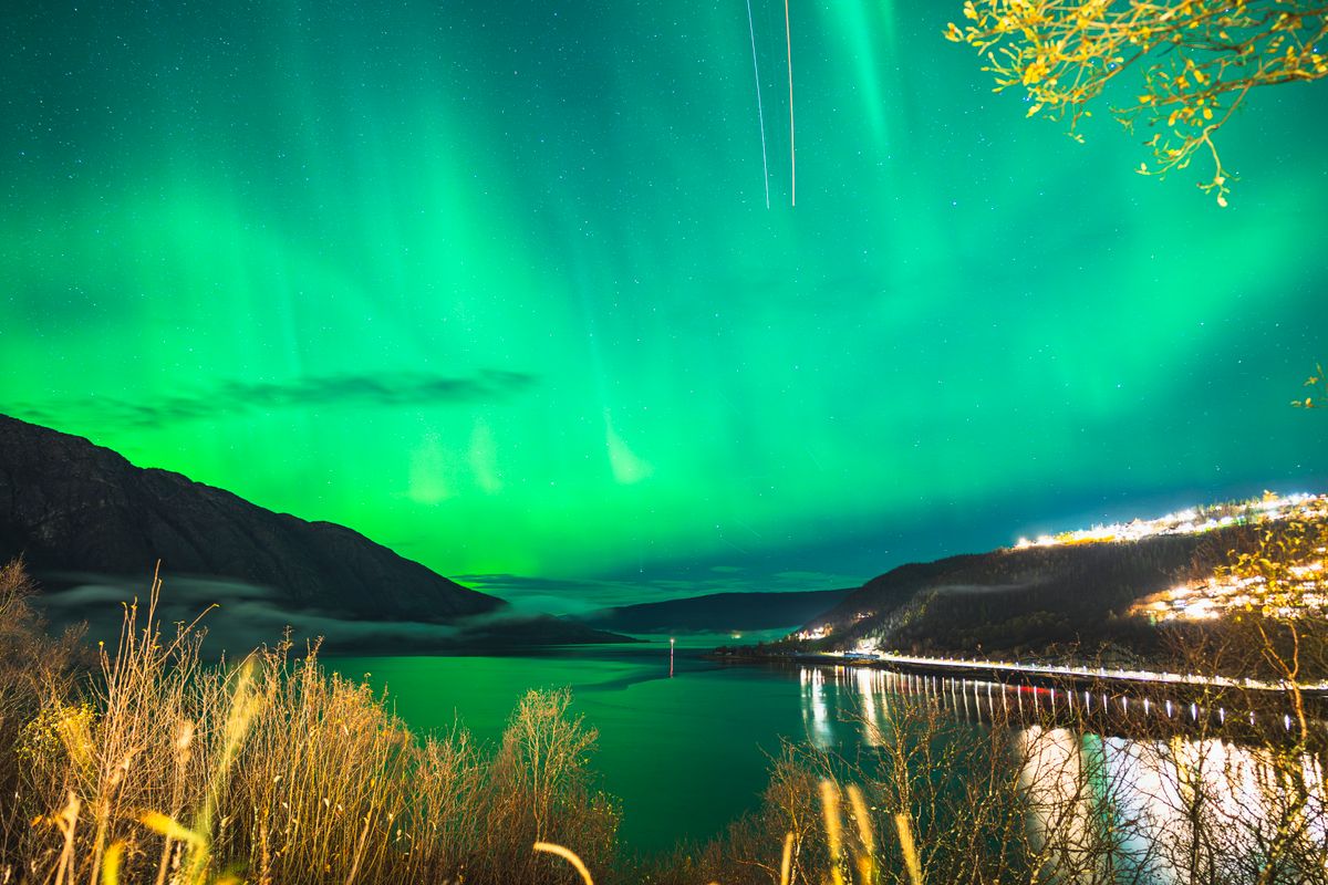 The Aurora Borealis over an Arctic fjord — a phenomenon defined by motion no still photograph can convey.