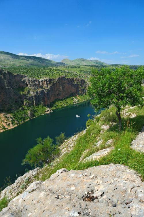 Free Beautiful canyon landscape with river, cliffs, and vibrant greenery on a sunny day. Stock Photo