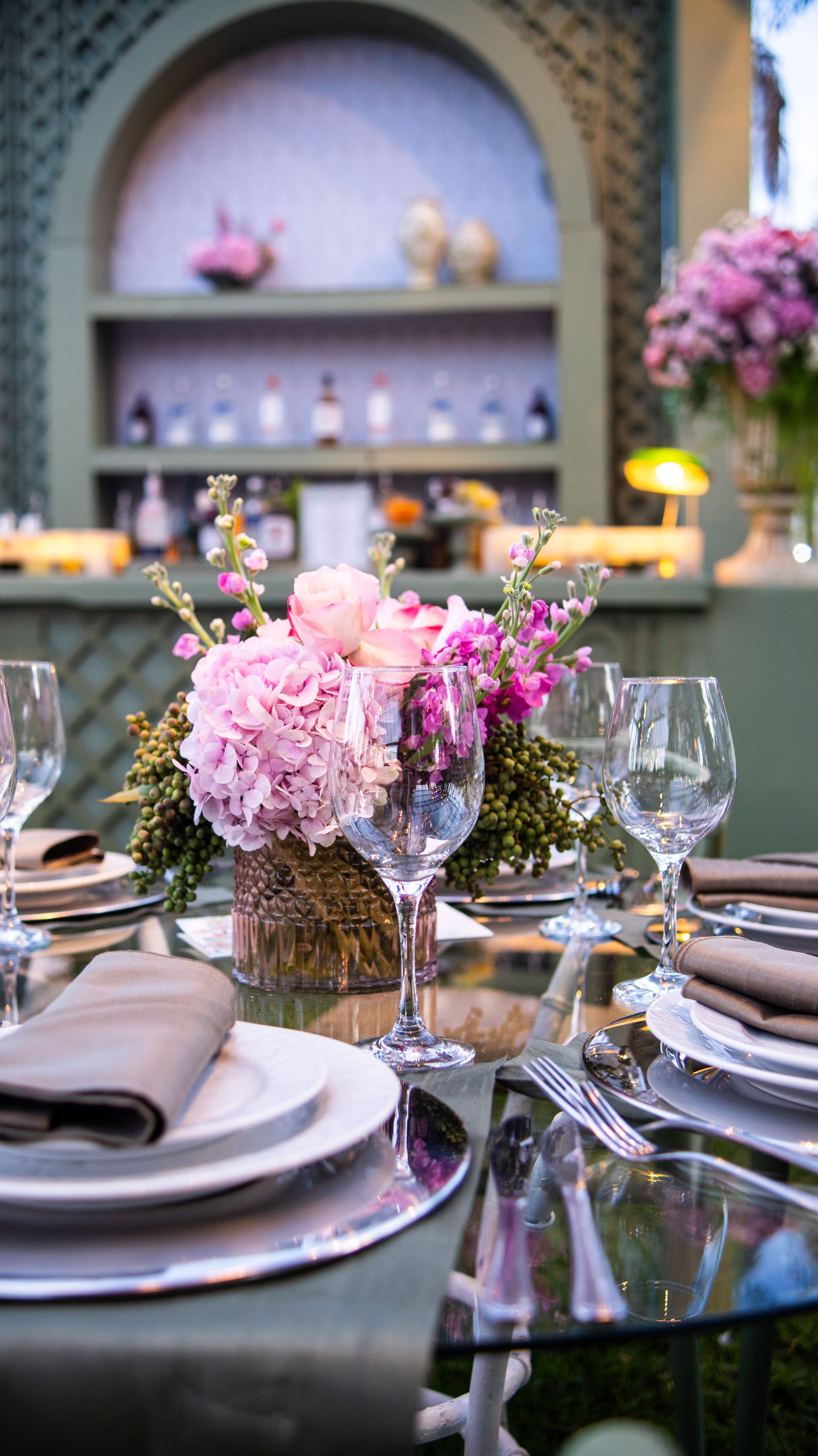 Configuração de mesa luxuosa com centro de mesa floral e cristais, perfeita para eventos sofisticados.