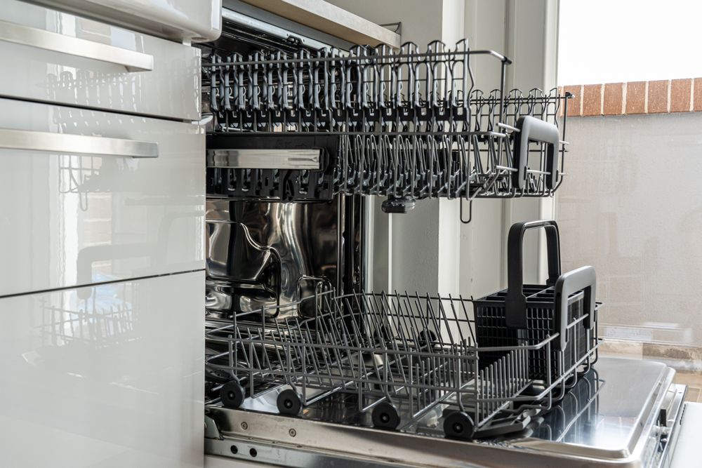 Open dishwasher with an empty rack in a modern kitchen