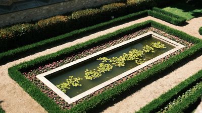 Aerial view of a rectangular garden water feature with geometric hedges