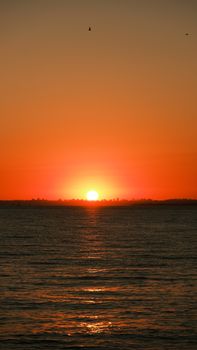 Stunning ocean sunset with vivid warm colors reflecting on the water surface.