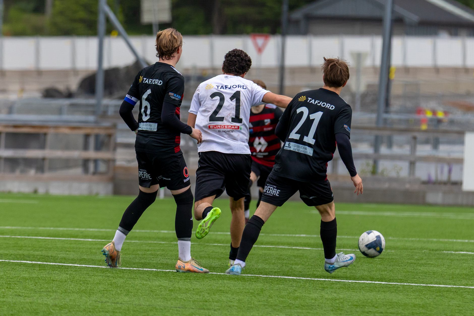 Norway defenders organizing a compact defensive wall while opponents prepare a free kick under stadium lights