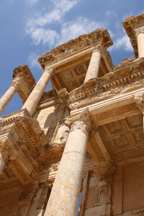 Free A low-angle view of ancient Roman architecture with ornate columns and detailed carvings against a clear sky. Stock Photo