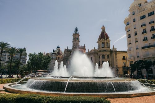 Free Beautiful fountain with historic buildings in Plaza del Ayuntamiento, Valencia, Spain. Stock Photo