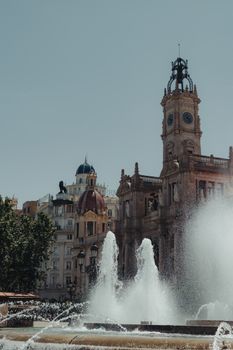 Fountain and architecture of Plaza del Ayuntamiento during the day in Valencia, Spain.