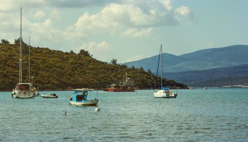 Free Tranquil marina scene in Sığacık, İzmir with boats and hills under a dramatic sky. Stock Photo