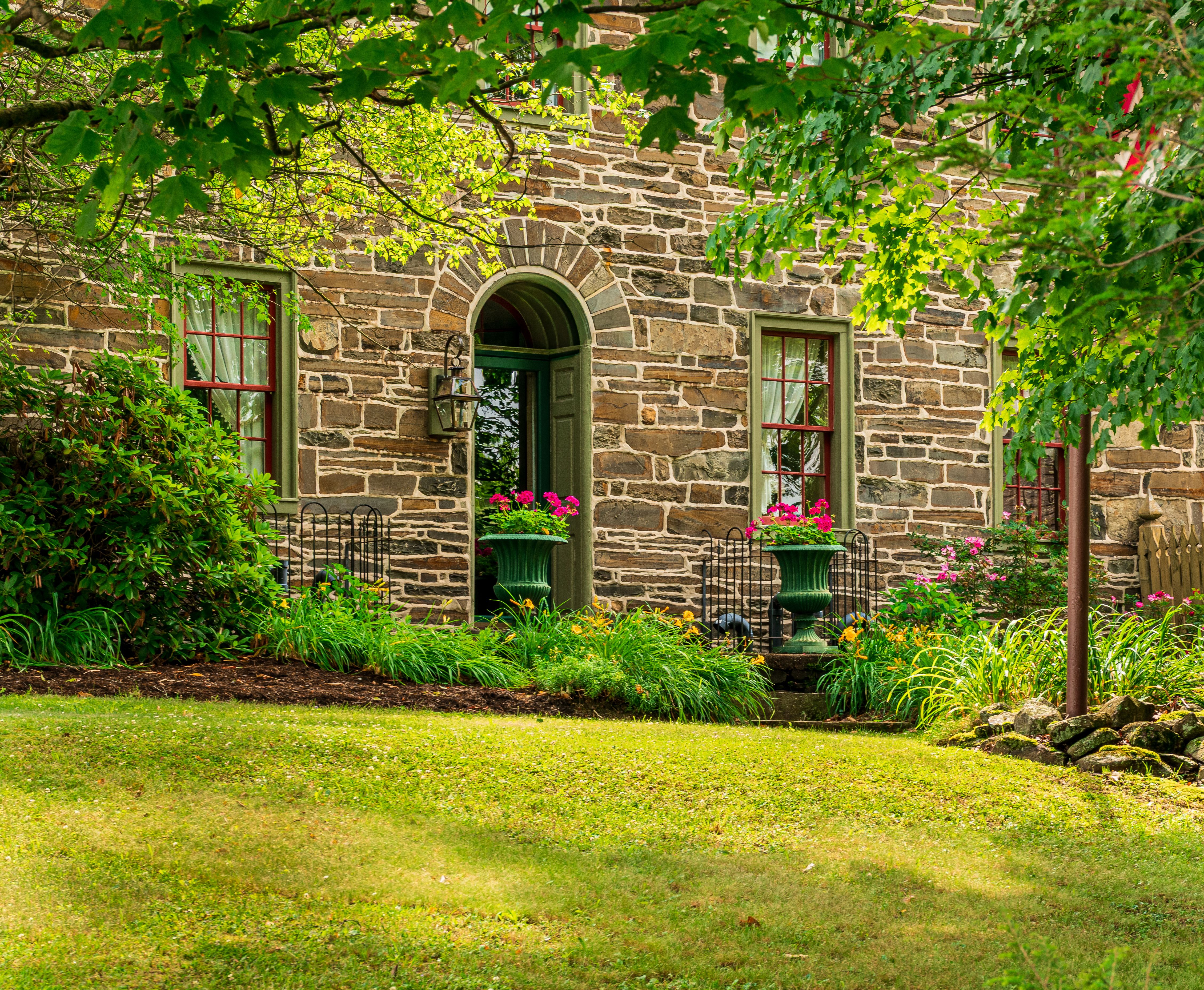 The lush back garden of the historic holiday home leading to the waterfront