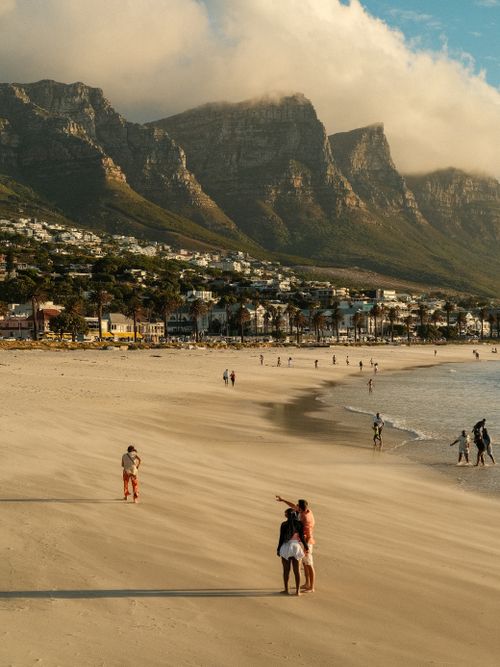 Free Stunning view of Camps Bay Beach with people enjoying the sunset against the backdrop of Table Mountain, Cape Town. Stock Photo