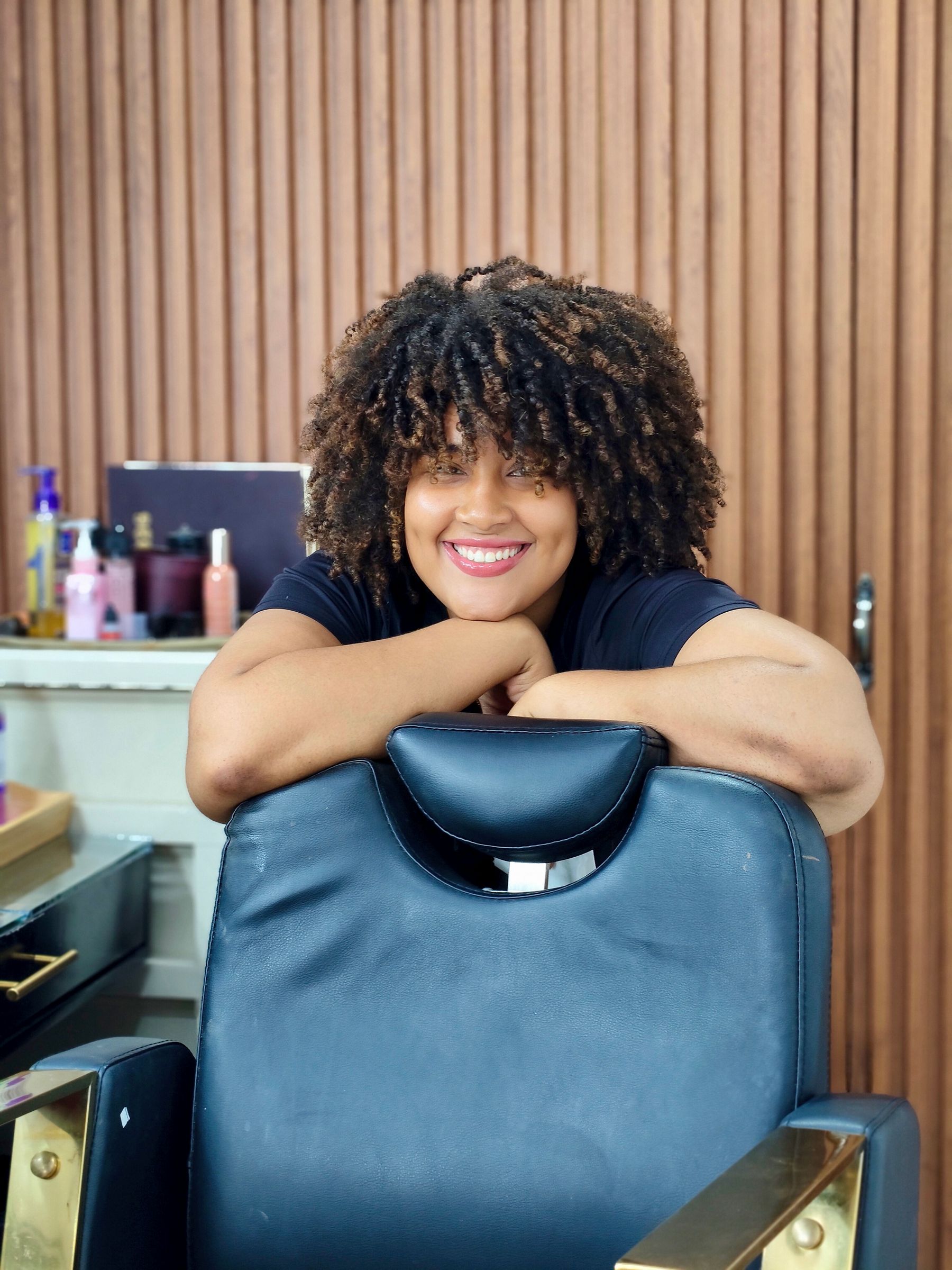 Black woman with natural textured curls in a salon
