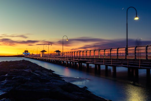 Captivating sunset view of St Kilda Pier in Melbourne with dramatic skies and tranquil water.