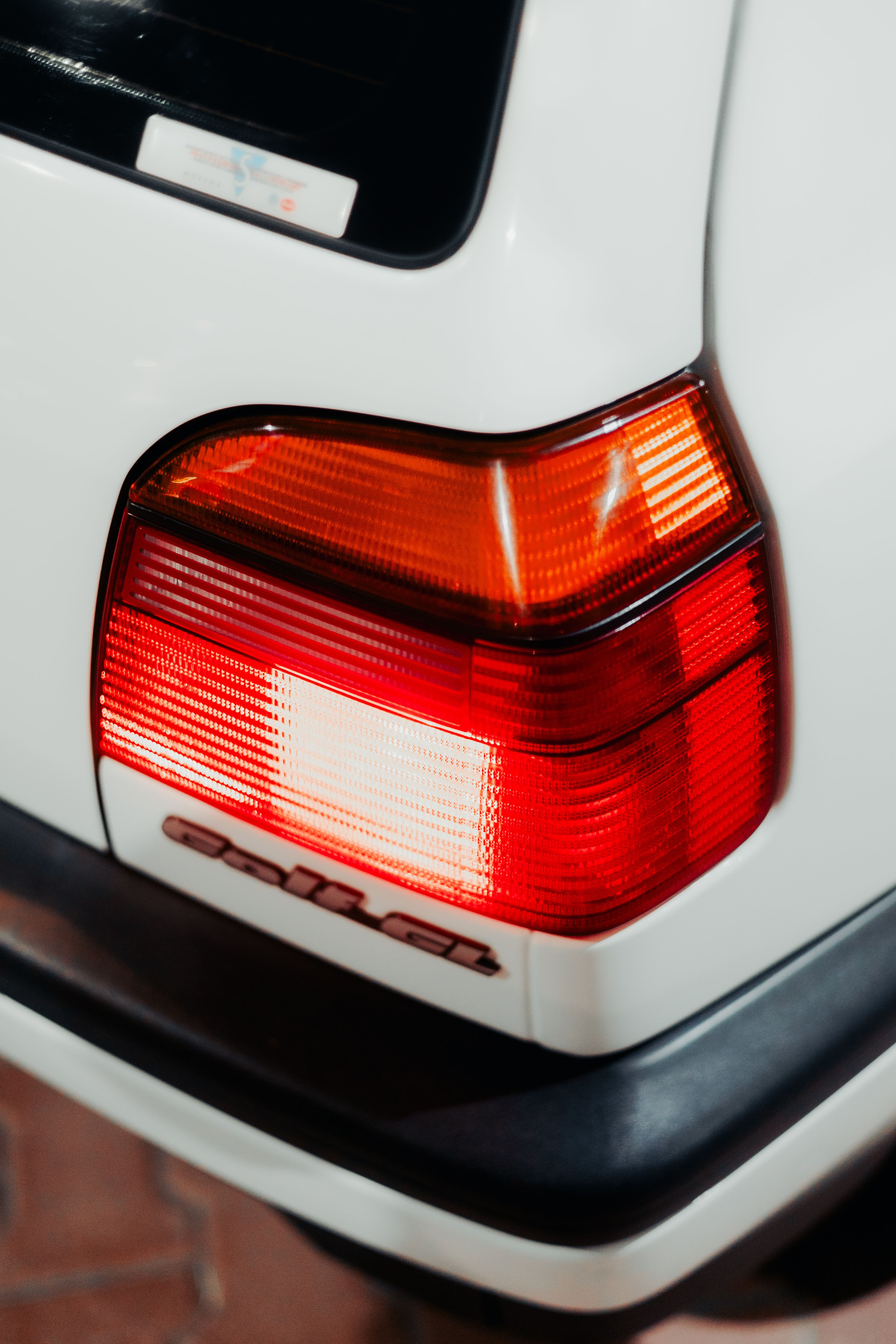 Detailed view of a vintage car's red tail light showcasing its classic design.