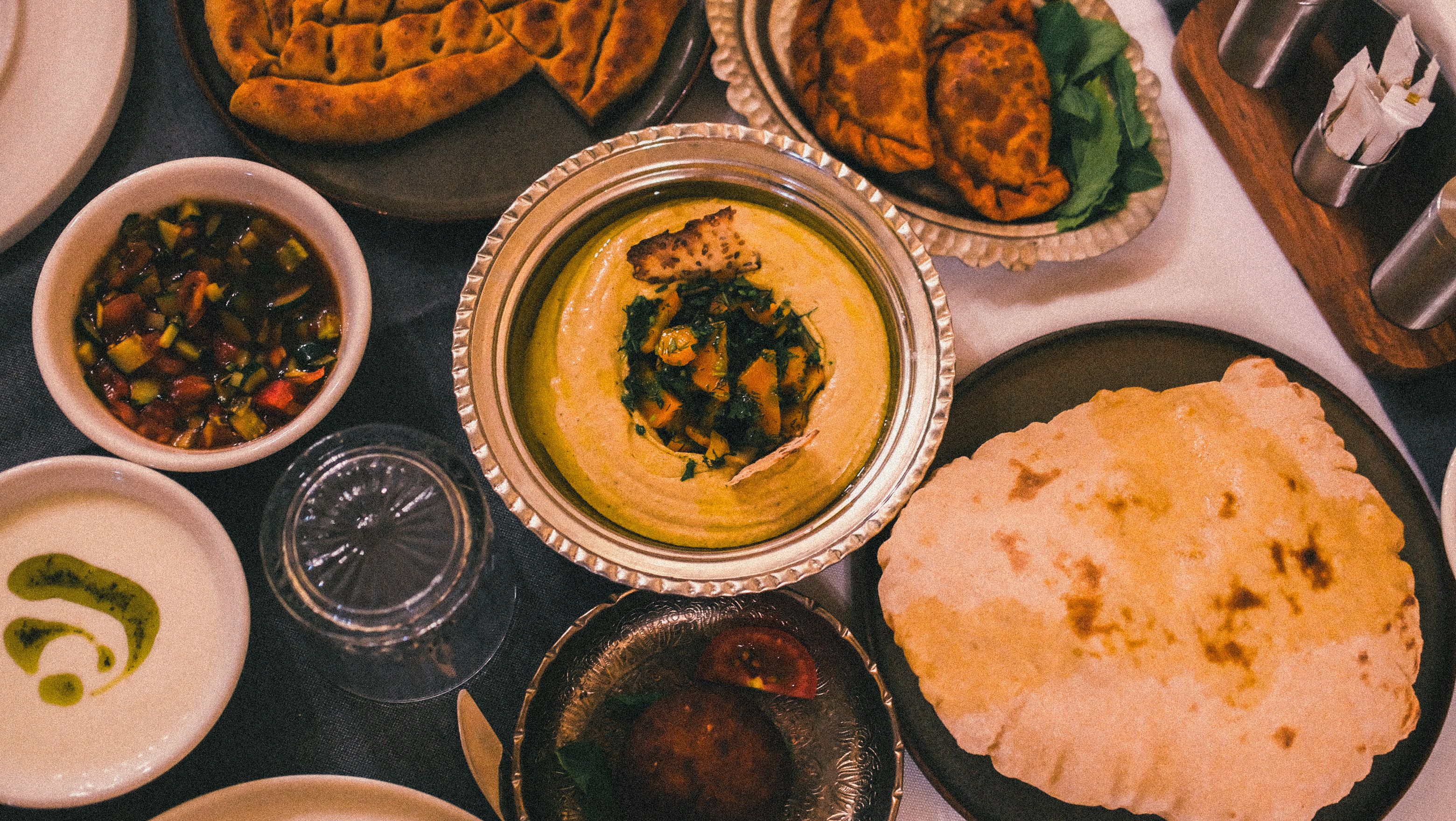 Delicious spread of Middle Eastern dishes including hummus and bread in Sanlurfa, Turkiye.
