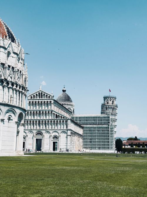 Free The iconic Leaning Tower of Pisa against a bright blue sky, showcasing its historic architecture. Stock Photo