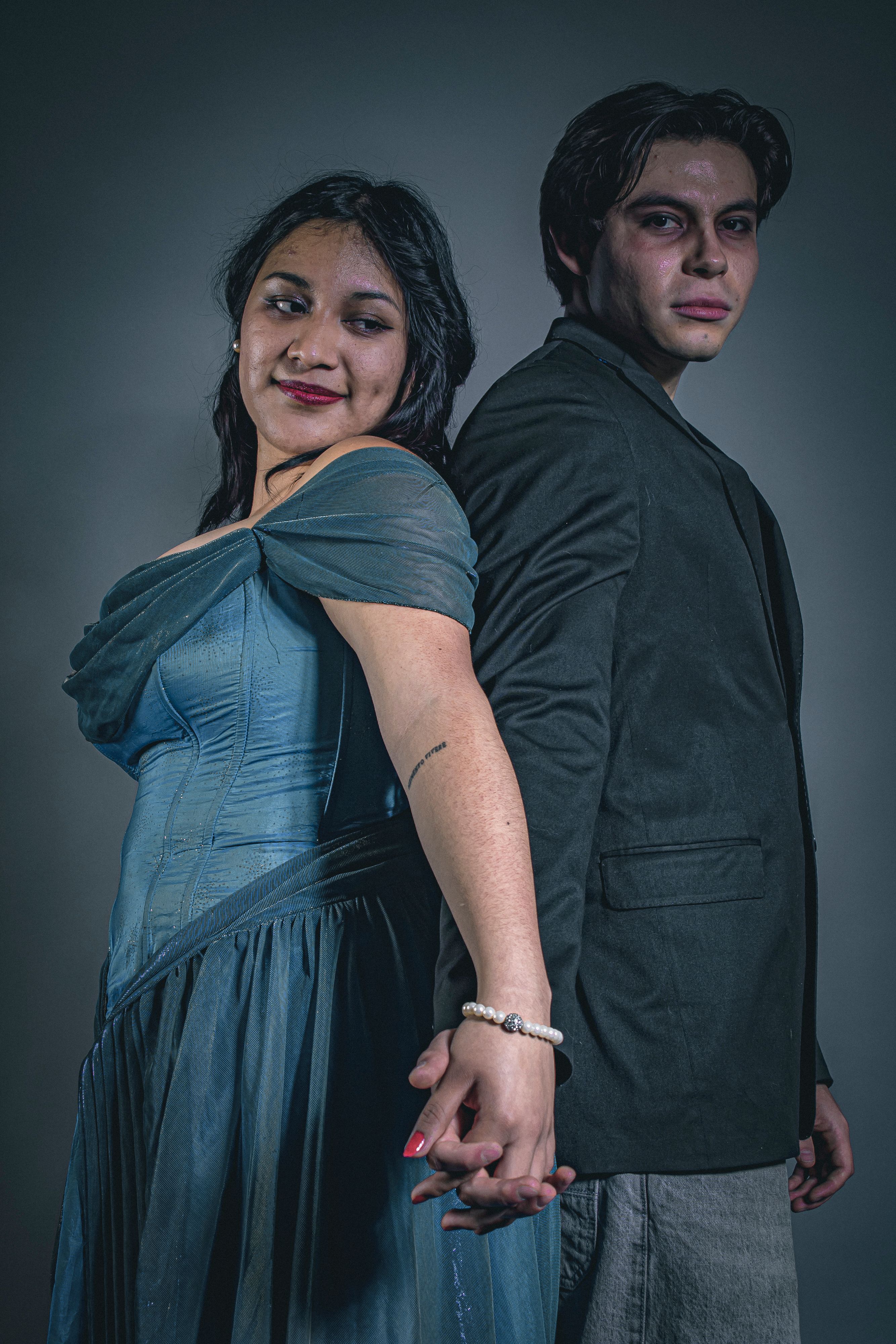 Elegant couple in formal wear posing back-to-back, exuding style and confidence.