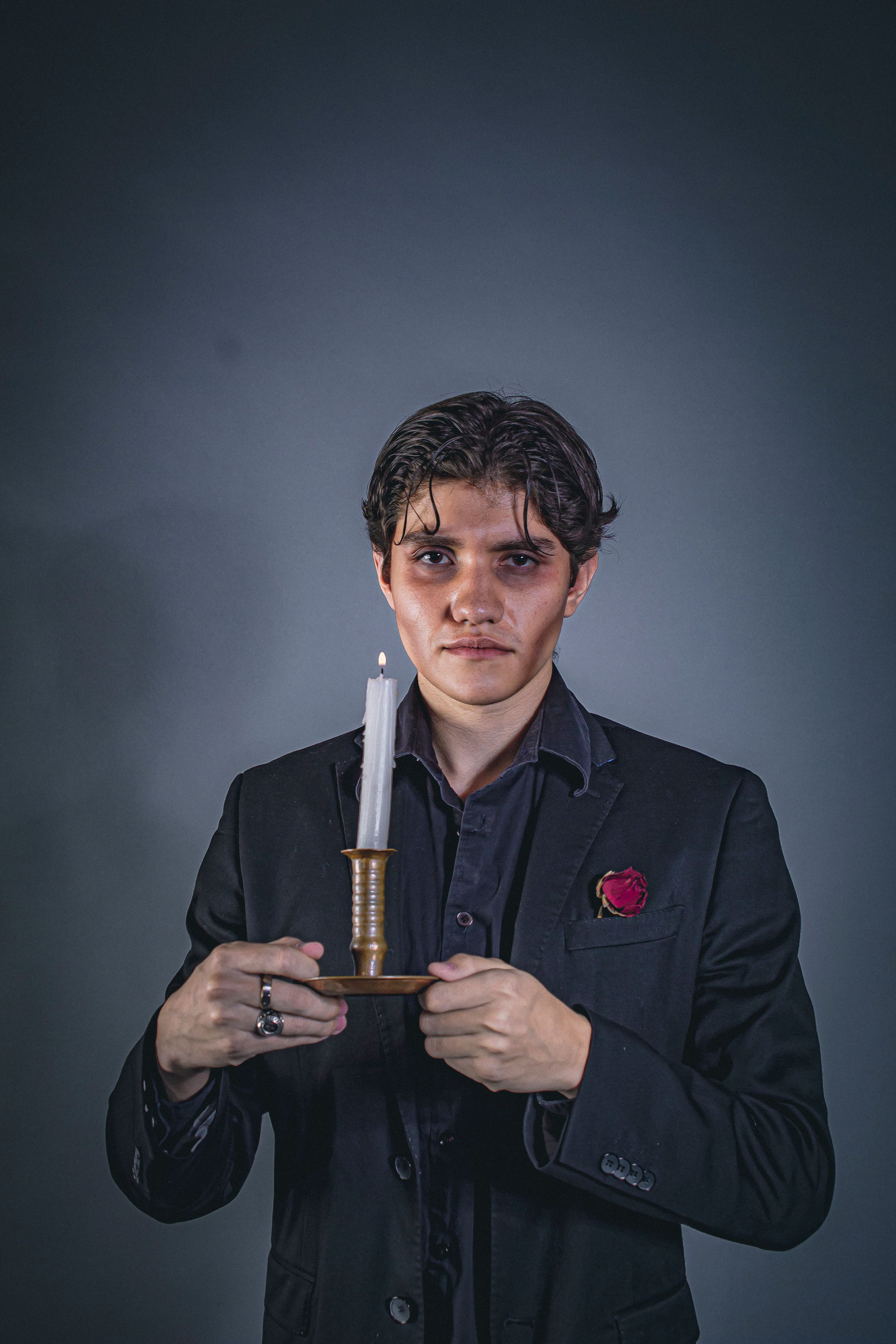 Young man holding a candle, creating a dramatic mood in Ciudad López Mateos, Mexico.