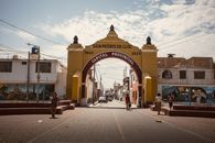 Street view of the archway in San Pedro de Lloc, Peru, showcasing vibrant urban life.