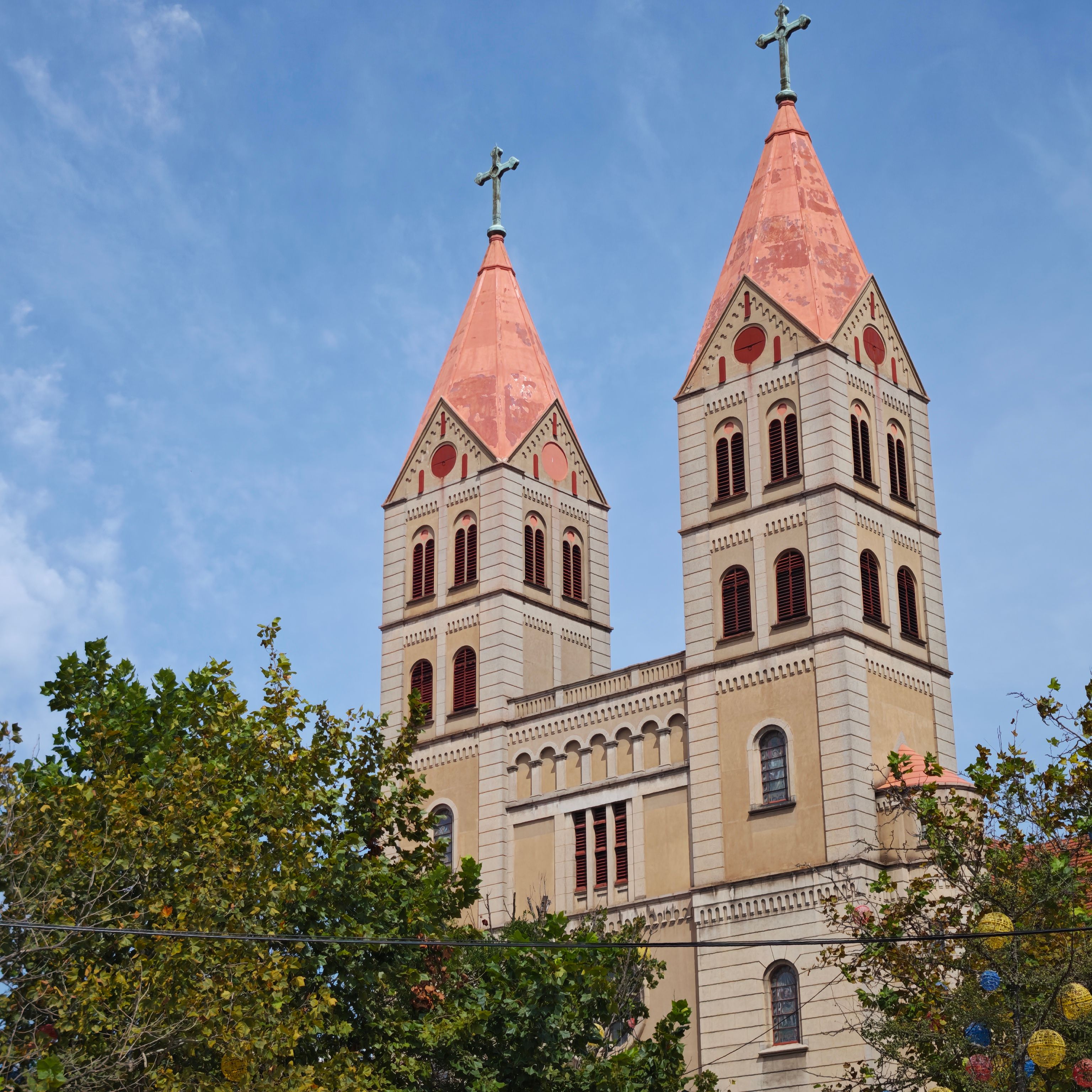 Stunning view of St. Michael's Cathedral's iconic twin towers in Qingdao against a clear blue sky.