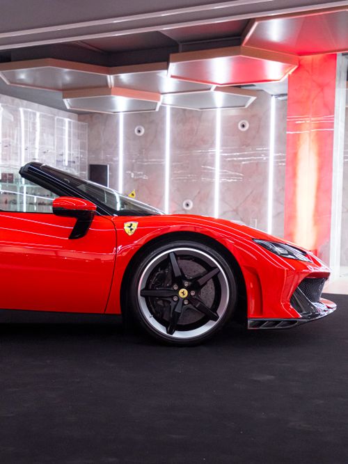 Free Close-up shot of a stunning red Ferrari showcased in a stylish indoor setting. Stock Photo