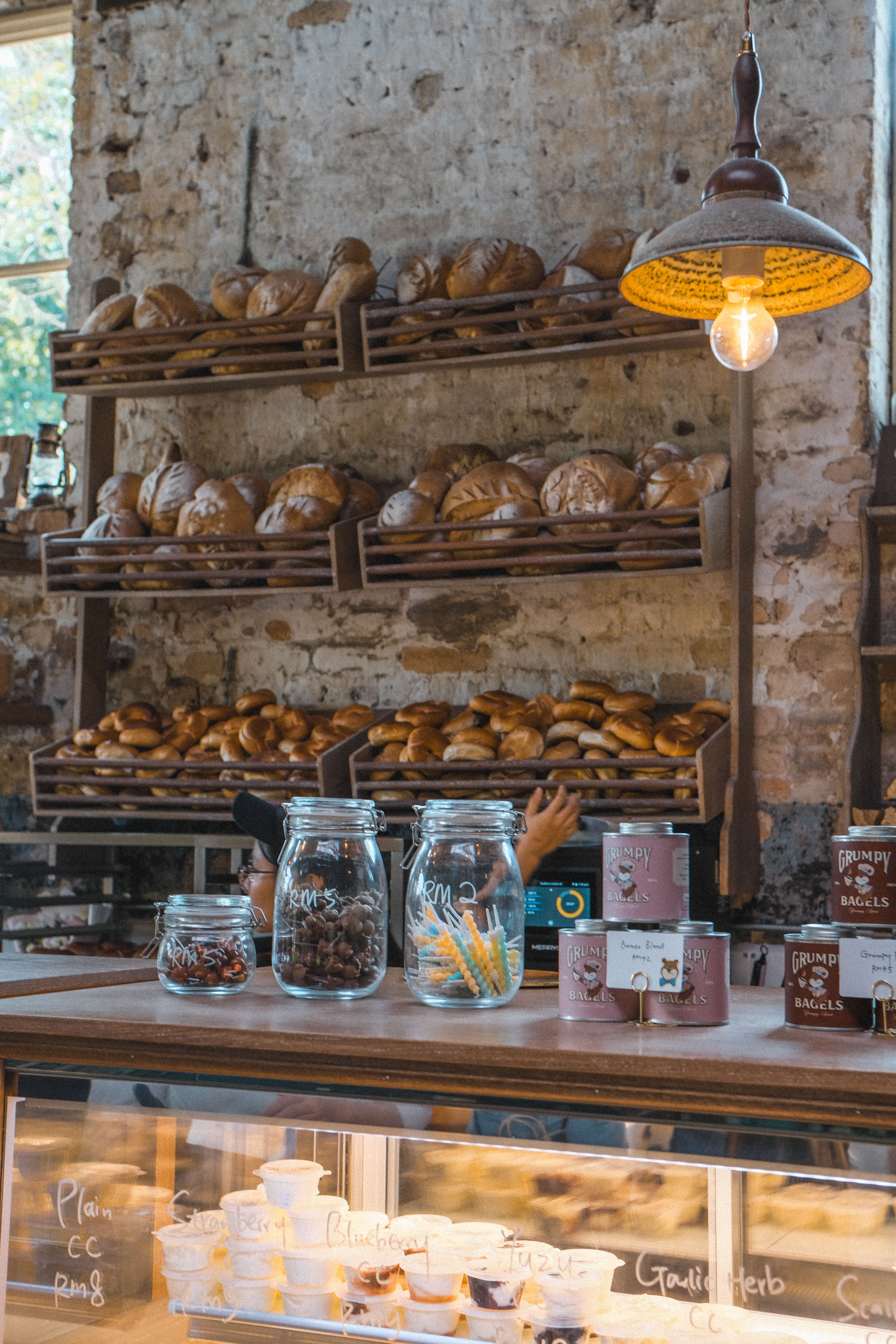 Cozy bakery interior with fresh bread on rustic shelves and glass jars.