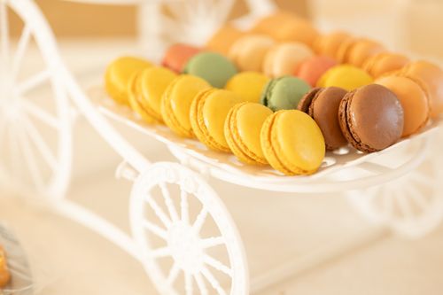 Free A selection of colorful macarons displayed on a white decorative cart. Stock Photo