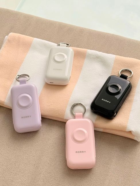 Personal safety alarms in pastel colors on fabric