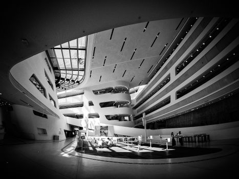 Black and white image of a spacious, modern architectural interior with sleek lines and curves.
