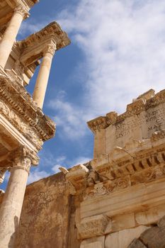 Stunning view of ancient Roman architecture with cloudy blue sky.