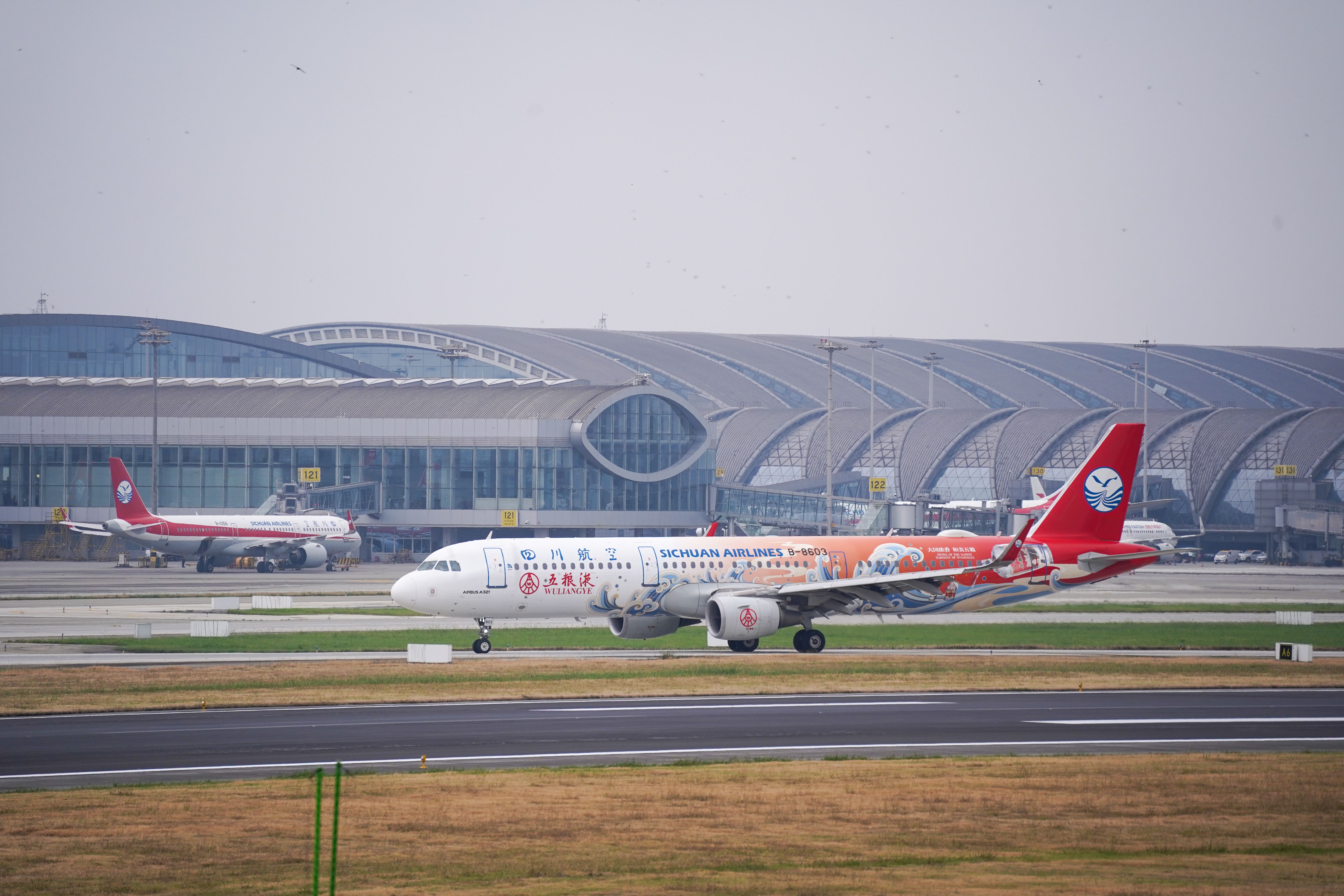 Sichuan Airlines plane at modern airport terminal — Photo by Peter Xie