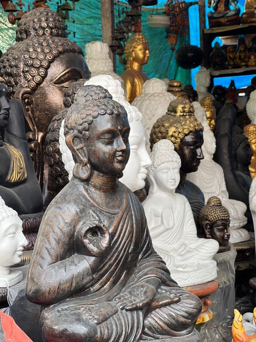 Free A vibrant collection of Buddha statues in a market stall in India, showcasing various artistic styles. Stock Photo