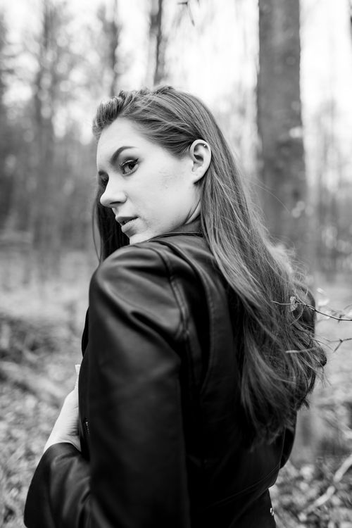 Free Elegant black and white portrait of a woman in a leather jacket, set outdoors. Stock Photo