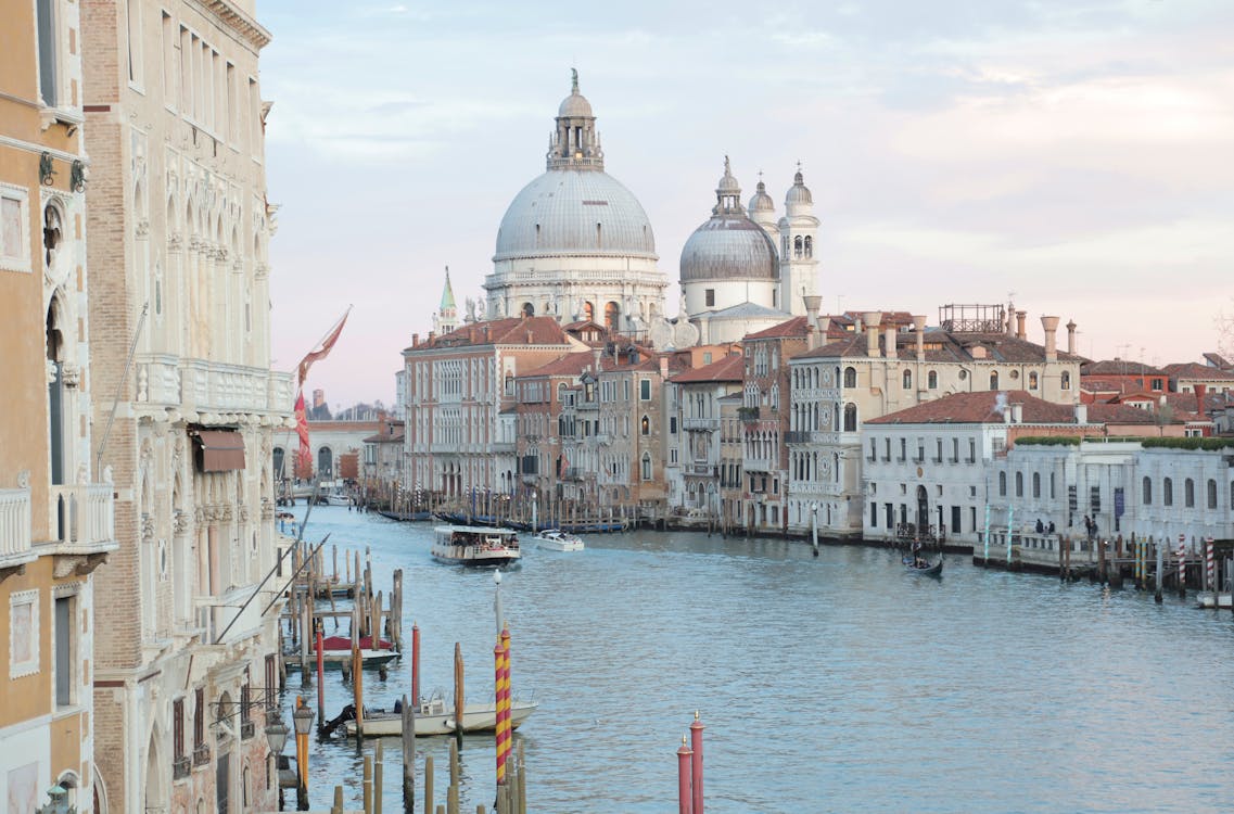 Free View of grand canal and old cathedral of Santa Maria della Salute in Venice in Italy on early calm morning Stock Photo