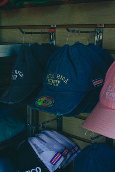 A vibrant display of Costa Rica themed caps in a retail store setting.