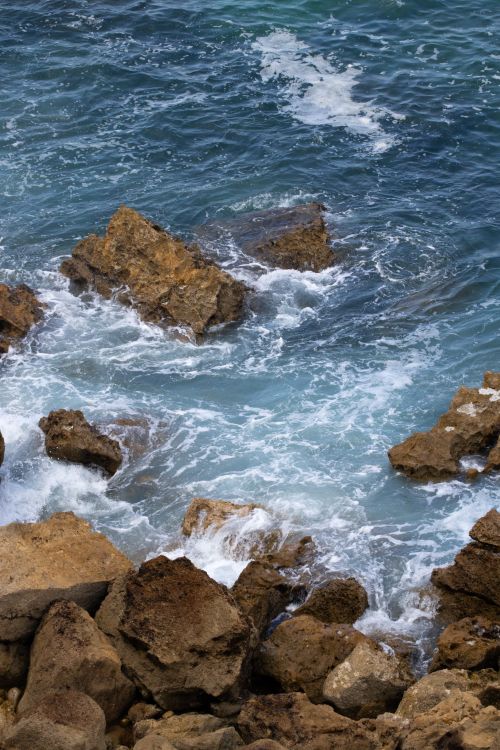 Free Dynamic ocean waves hitting rocky shores, showing sea textures. Stock Photo