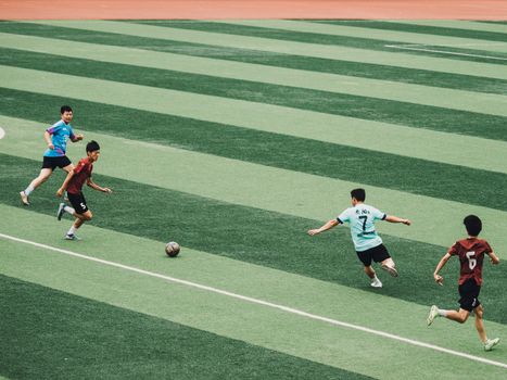 Dynamic soccer match with teenagers playing on a vibrant green field.