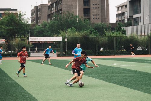 Free Players compete in an amateur soccer match on an urban field. Stock Photo