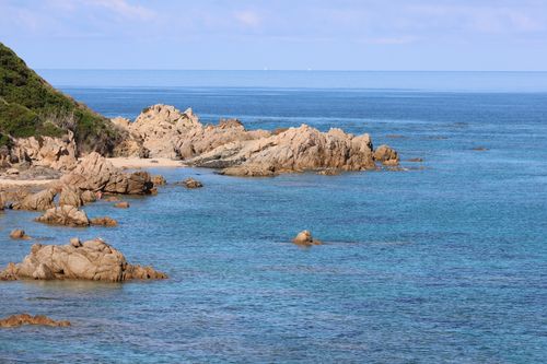 Free Vibrant coastal scene showcasing rocky shores and azure sea waters under a clear day. Stock Photo