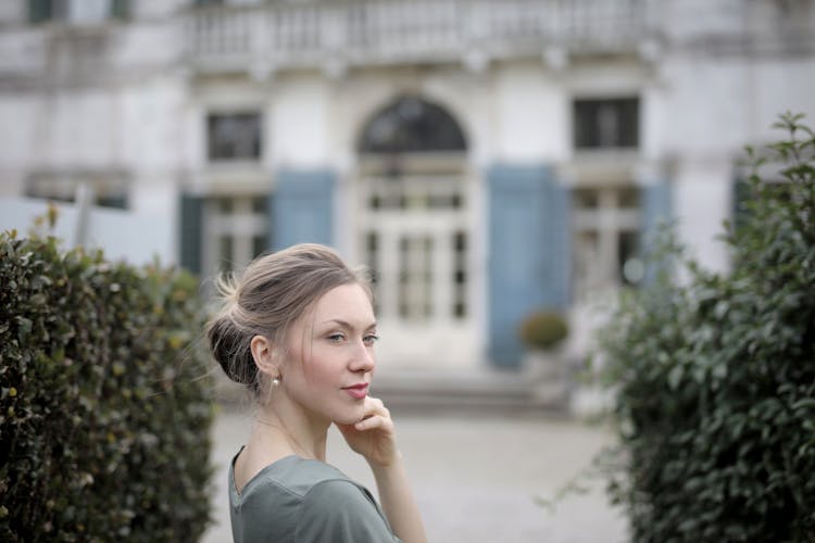 Pensive Woman On Background Of Old Palace Among Plants