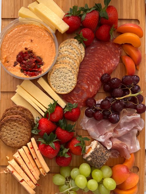 Free Colorful party platter featuring a variety of cheeses, fruits, and cured meats elegantly arranged. Stock Photo