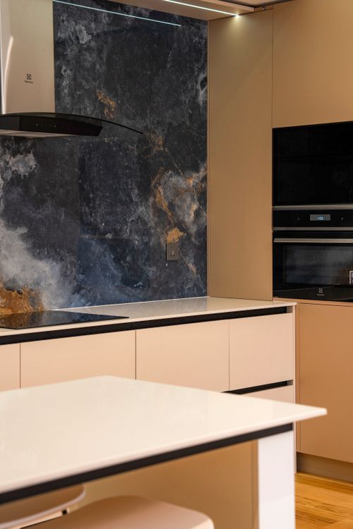 Free Sleek modern kitchen featuring a marble backsplash and high-end appliances. Stock Photo