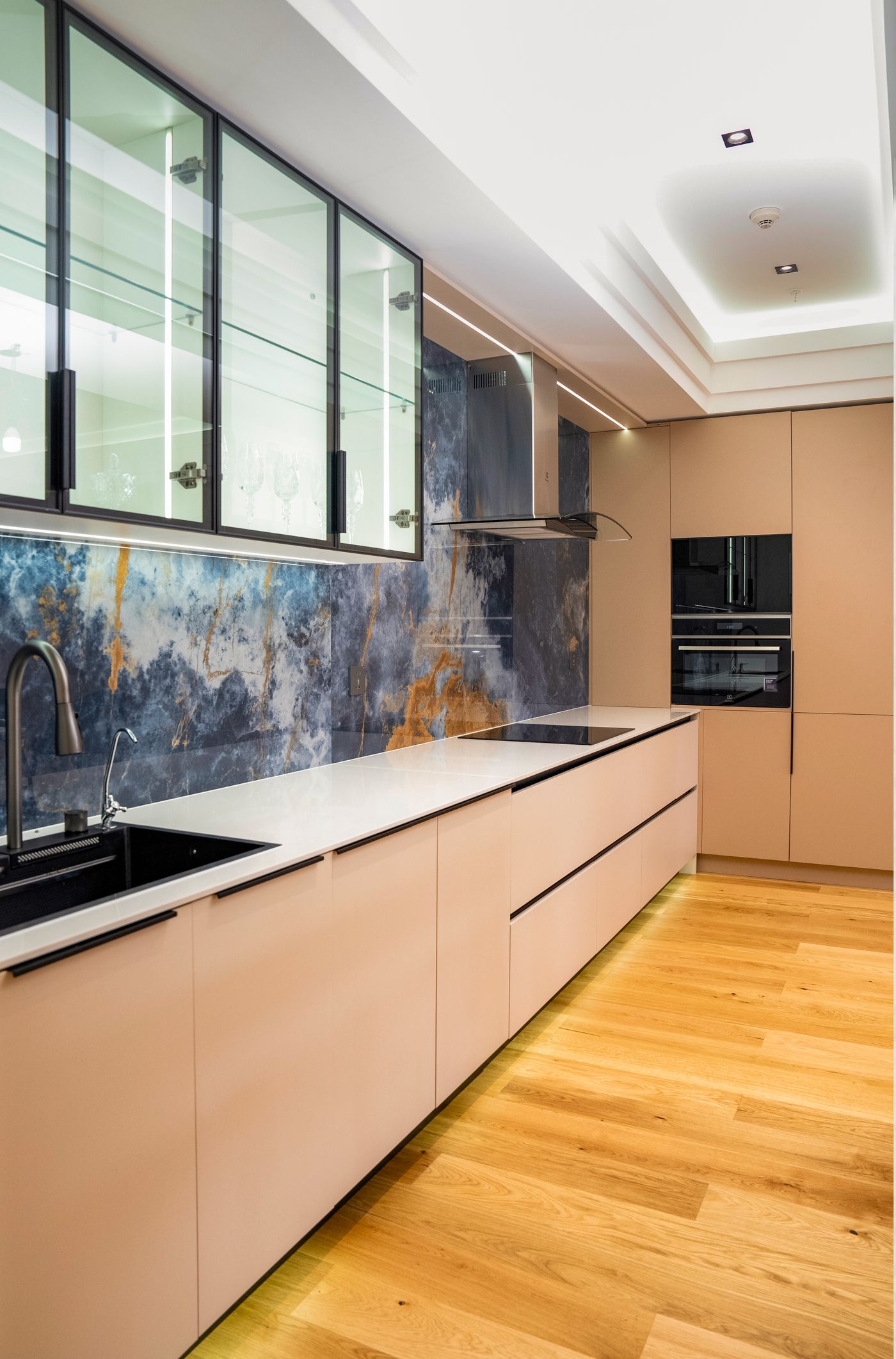 Cozinha planejada contemporânea com portas lisas, pedra decorativa e iluminação embutida