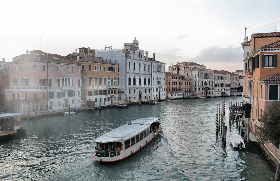 Free Venice waterway with old buildings and ferry Stock Photo