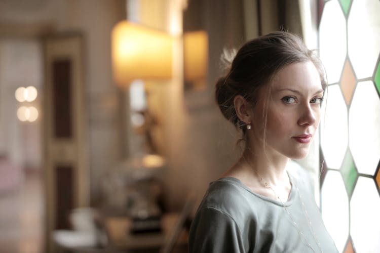 Pensive Woman In Luxury Room Near Window On Sunny Day