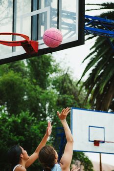 Outdoor basketball game in Ciudad de México with a pink ball and players shooting.